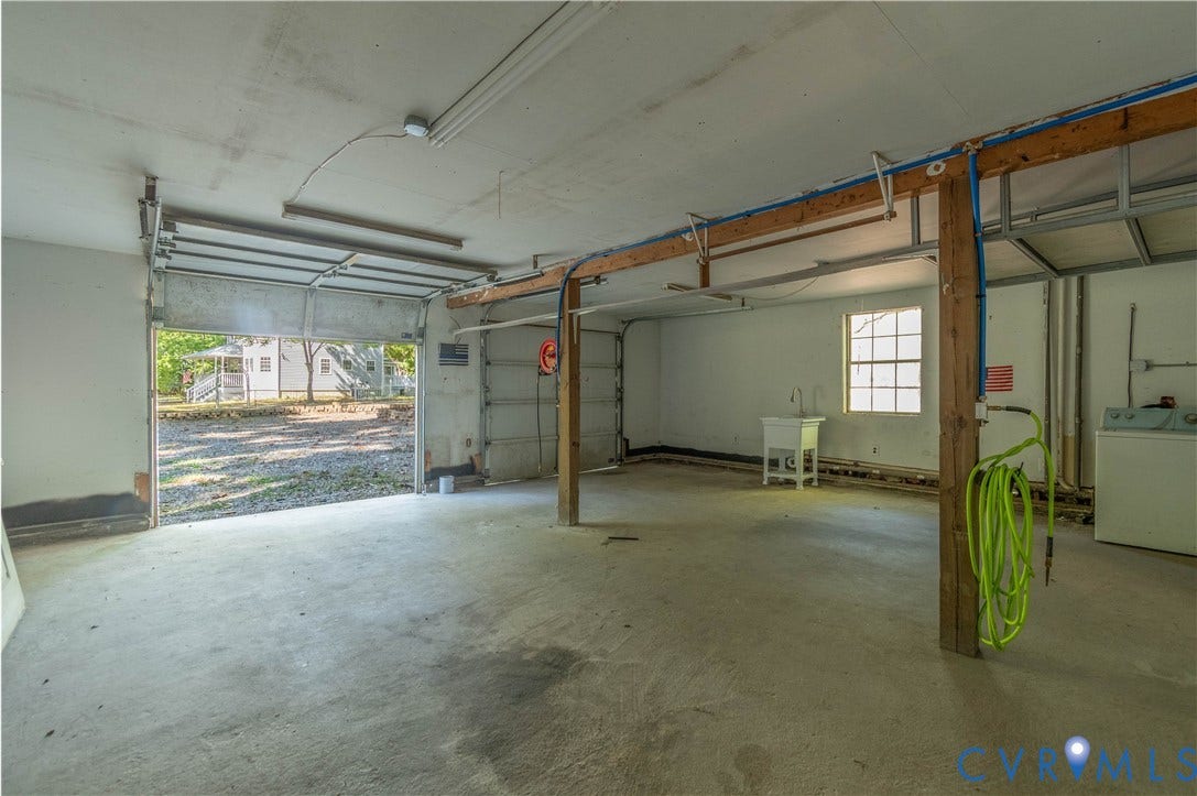 9045 Blounts Corner Road, Smithfield, VA 23430 Multi-car garage featuring a concrete floor, structural wood support beams, a utility basin, and natural lighting provided by a single-pane window