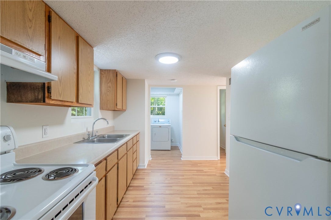 9045 Blounts Corner Road, Smithfield, VA 23430 Kitchen featuring wood-finish cabinetry, solid-surface countertops, dual-basin stainless steel sink, white electric range, and wood-finish flooring