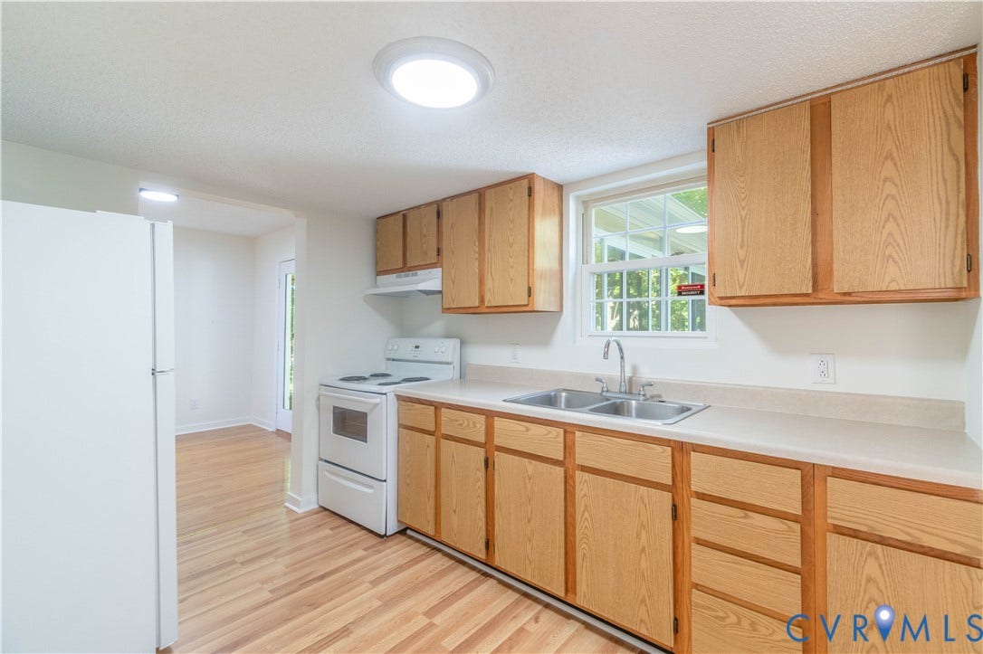 9045 Blounts Corner Road, Smithfield, VA 23430 Kitchen featuring wood cabinetry, solid-surface countertops, dual-basin stainless steel sink, and white electric range