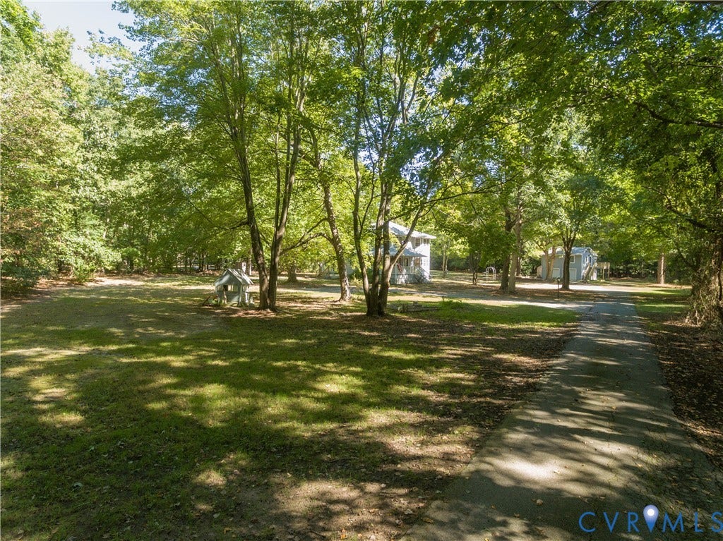 9045 Blounts Corner Road, Smithfield, VA 23430 Expansive lot featuring mature hardwood trees, established perimeter landscaping, and an elongated paved driveway