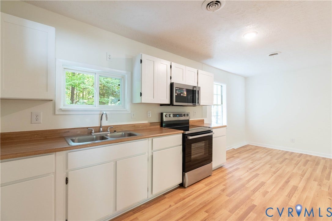 9045 Blounts Corner Road, Smithfield, VA 23430 Kitchen featuring white shaker-style cabinetry, wood-finish countertops, stainless steel appliances, double-basin sink, and wood-finish flooring