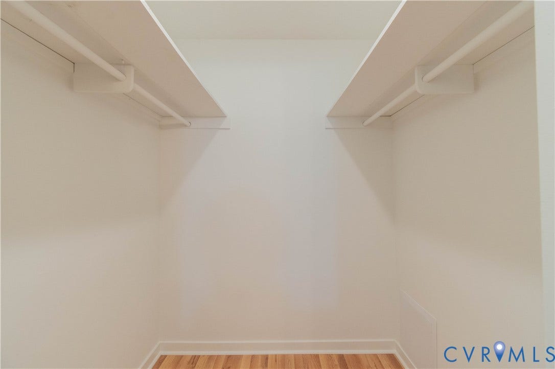 9045 Blounts Corner Road, Smithfield, VA 23430 Storage area featuring dual overhead shelving with integrated hanging rods and wood-finish flooring