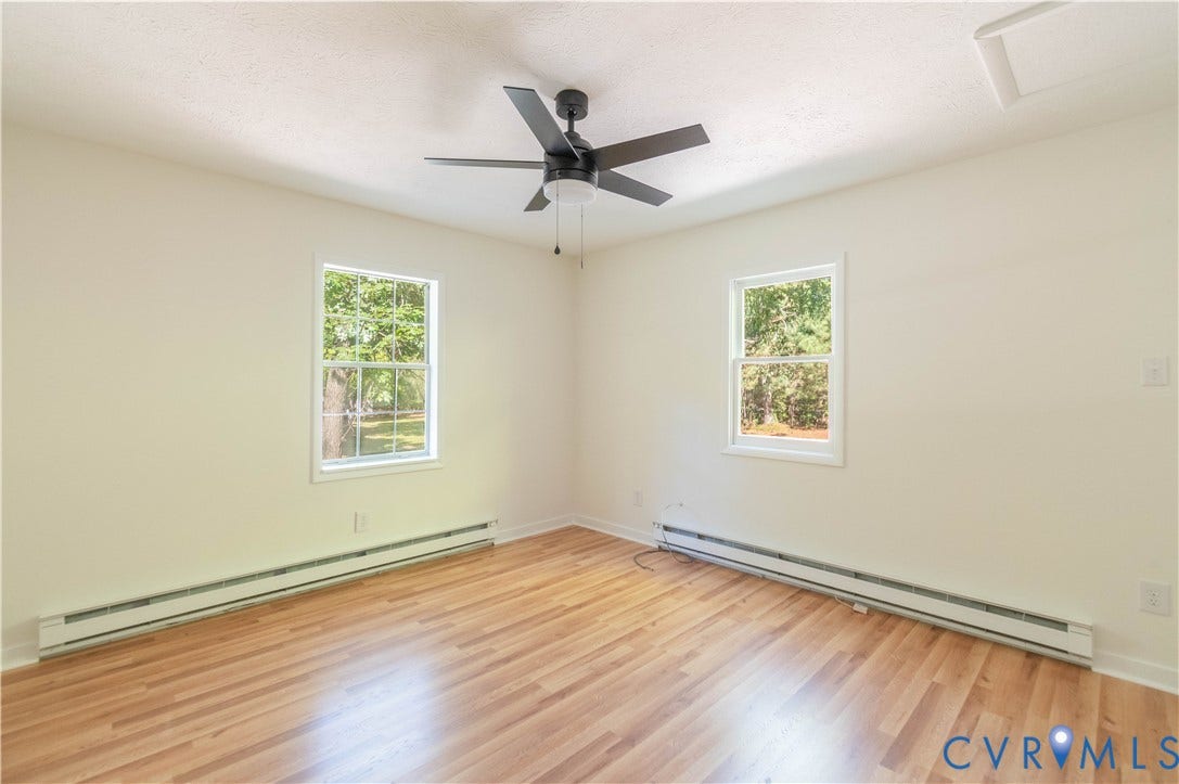 9045 Blounts Corner Road, Smithfield, VA 23430 Interior space featuring wood-finish flooring, two double-hung windows, and a ceiling fan with integrated lighting