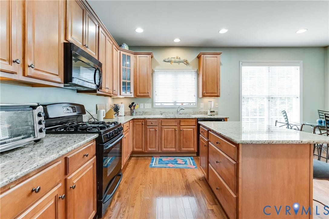 704 Taylors Hill Court, Manakin Sabot, VA 23103 Wood-finish flooring, light wood cabinetry, stone countertops, black appliances, and a sliding glass door
