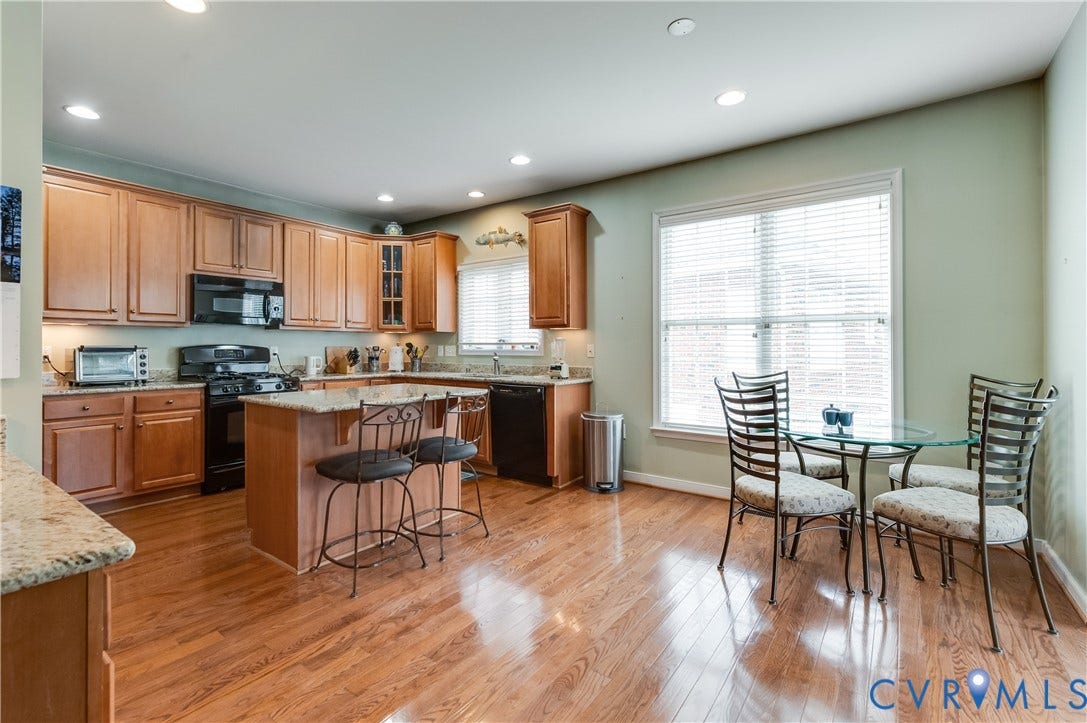 704 Taylors Hill Court, Manakin Sabot, VA 23103 Spacious kitchen featuring wood-finish flooring, ample cabinetry, granite countertops, and a central island with bar seating