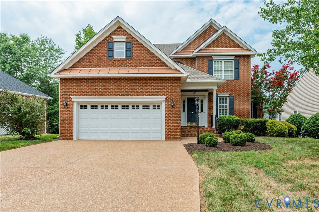 704 Taylors Hill Court, Manakin Sabot, VA 23103 Brick facade residence featuring a two-car garage, covered entry, front shutters, and a decorative dormer