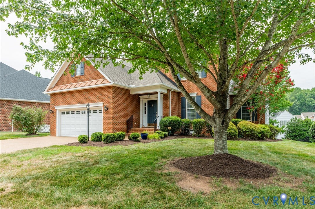 704 Taylors Hill Court, Manakin Sabot, VA 23103 Brick exterior featuring a two-car garage with white paneled doors, dormer window, and an inviting front entry with sidelights