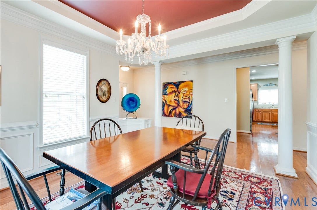 704 Taylors Hill Court, Manakin Sabot, VA 23103 Formal dining space featuring a tray ceiling with a central chandelier, hardwood flooring, and wainscoting