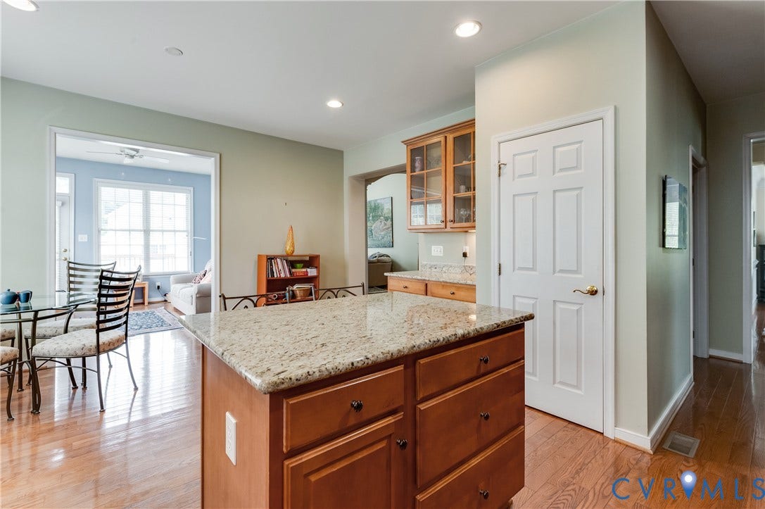 704 Taylors Hill Court, Manakin Sabot, VA 23103 Kitchen featuring wood-finish flooring, a central island with a granite countertop, wood cabinetry with glass-front uppers, and recessed lighting