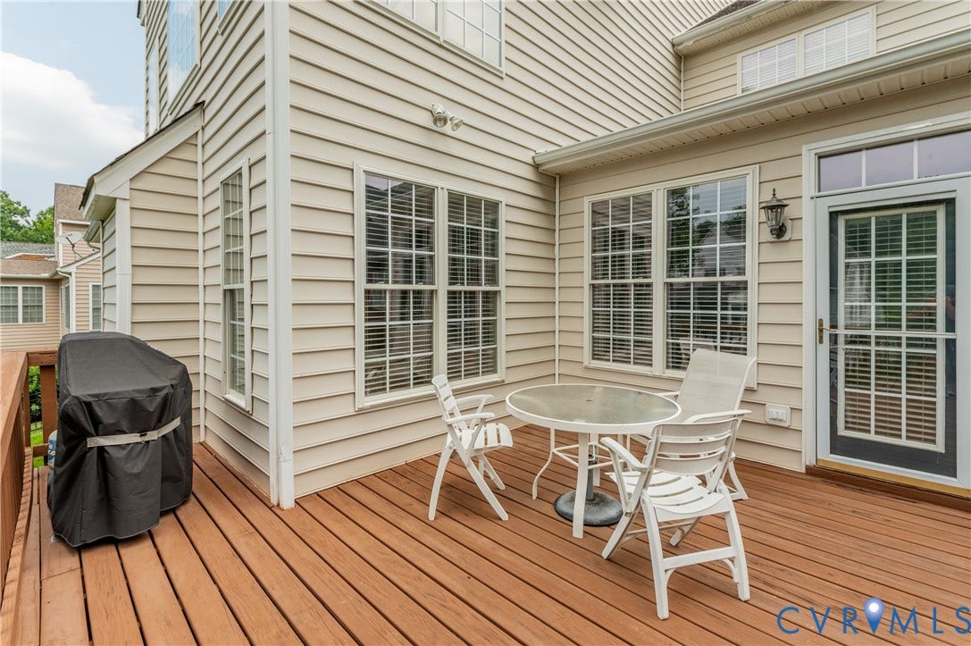 704 Taylors Hill Court, Manakin Sabot, VA 23103 Expansive wood-finish deck featuring light beige siding, multiple paneled windows, and a glass-paneled door