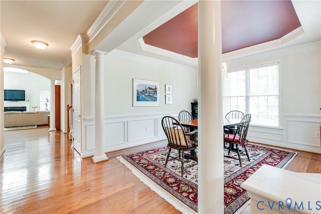 704 Taylors Hill Court, Manakin Sabot, VA 23103 Formal dining space featuring a tray ceiling with a contrasting inset, large windows, and wainscoting