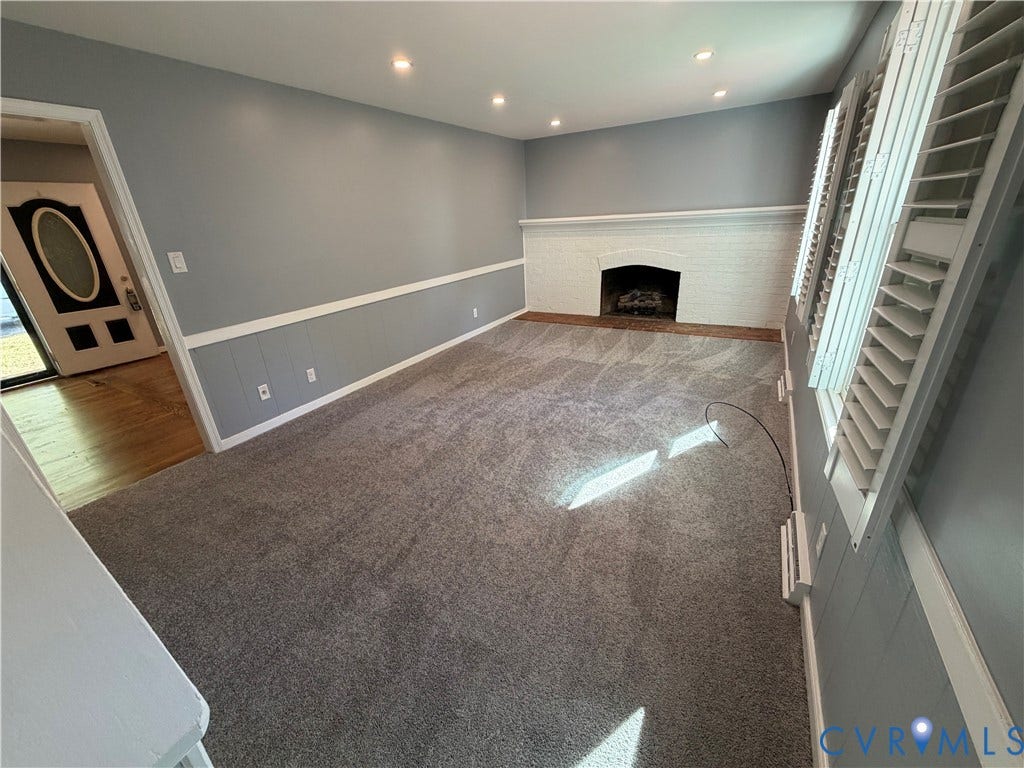 2228 Early Settlers Road, Midlothian, VA 23235 Interior room featuring a painted brick fireplace, white decorative chair rail molding, recessed lighting, and white plantation-style shutters