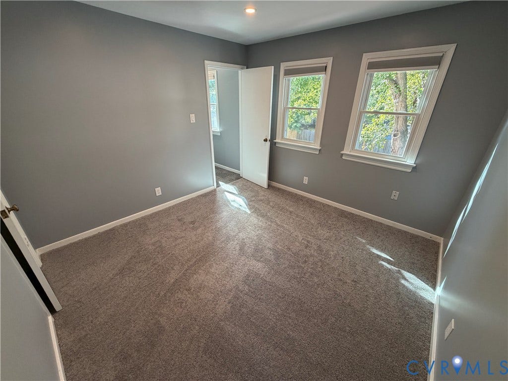 2228 Early Settlers Road, Midlothian, VA 23235 Interior room featuring neutral-toned carpeting, two windows with installed shades, and light grey wall paint