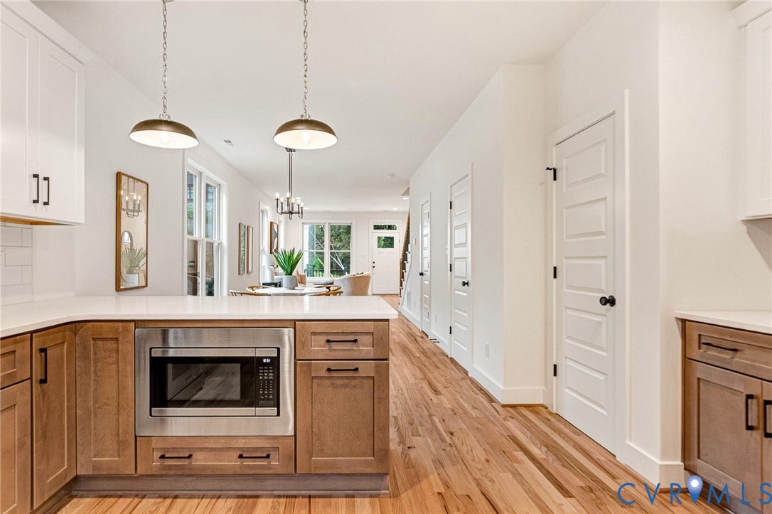 3021 E Franklin Street, St. John's Church, Richmond, VA 23223 Kitchen featuring wood-finish cabinetry, white countertops, built-in stainless steel microwave, metal pendant lighting, and wood-finish flooring