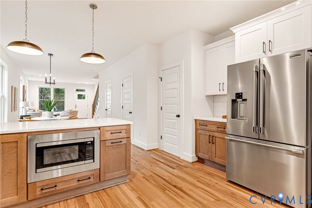 3021 E Franklin Street, St. John's Church, Richmond, VA 23223 Kitchen featuring two-tone cabinetry, stainless steel appliances, quartz countertops, wood-finish flooring, and pendant lighting