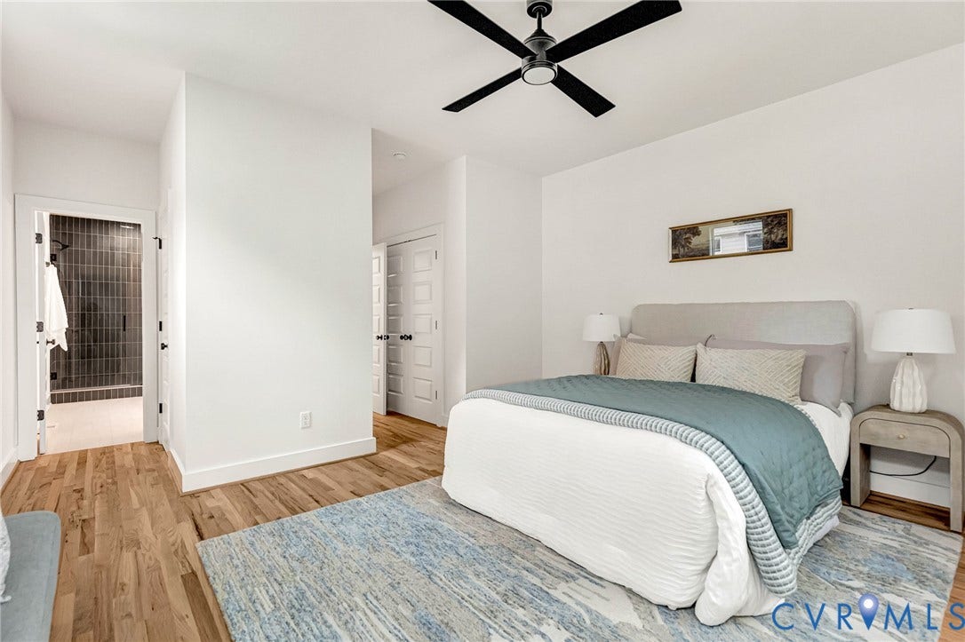 3021 E Franklin Street, St. John's Church, Richmond, VA 23223 Wood-finish flooring, multi-panel doors with matte black hardware, matte black ceiling fan, and walk-in shower with vertical tile surround