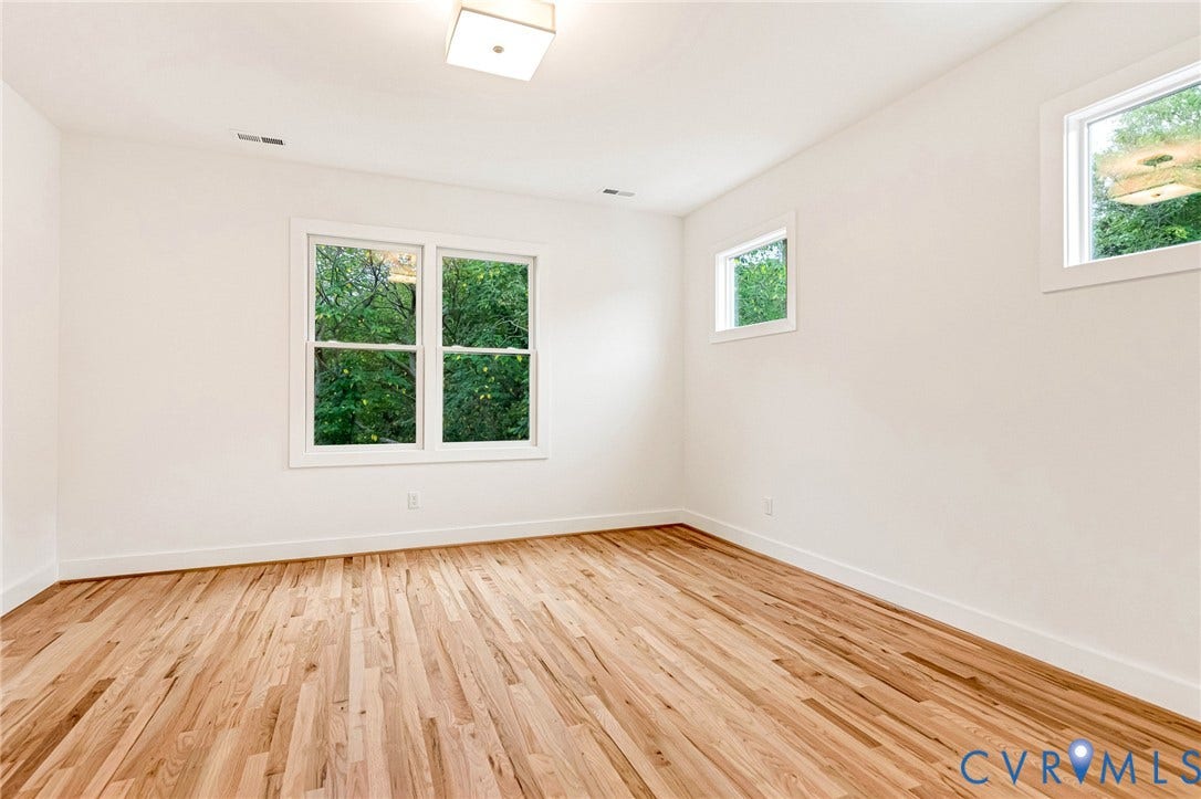 3021 E Franklin Street, St. John's Church, Richmond, VA 23223 Bright room featuring wood-finish flooring, white walls, double-pane windows, and a flush-mount ceiling light fixture