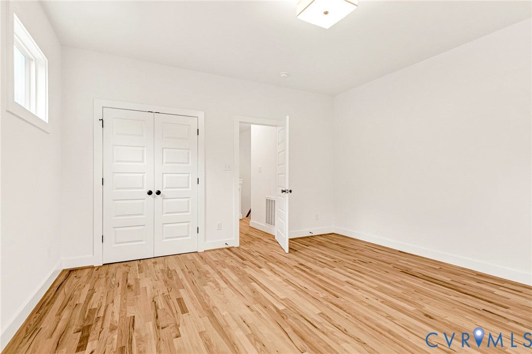 3021 E Franklin Street, St. John's Church, Richmond, VA 23223 Interior room featuring wood-finish flooring, white walls, double doors with matte black hardware, and a square flush-mount ceiling light fixture