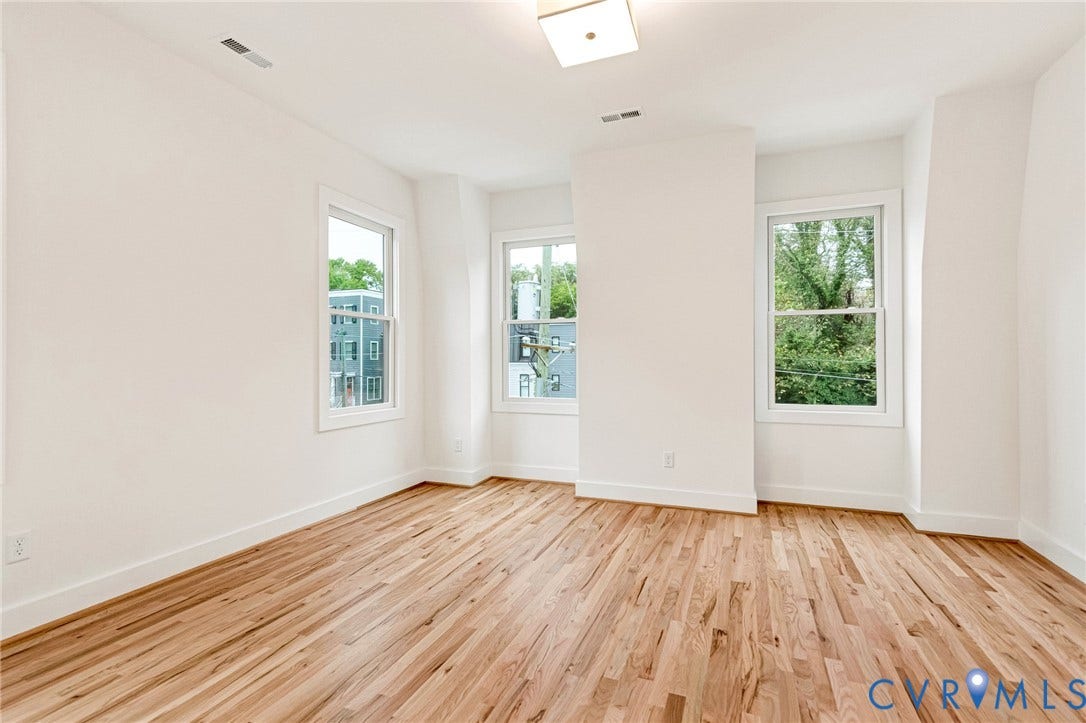 3021 E Franklin Street, St. John's Church, Richmond, VA 23223 Interior space featuring wood-finish flooring, white walls, three double-hung windows, and a flush-mount light fixture