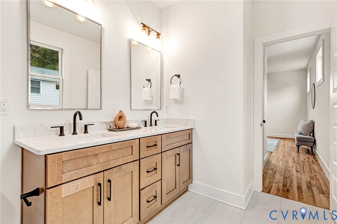 3021 E Franklin Street, St. John's Church, Richmond, VA 23223 Dual-sink vanity with light wood-finish cabinetry, stone countertop, matte black fixtures, and two rectangular wall-mounted mirrors