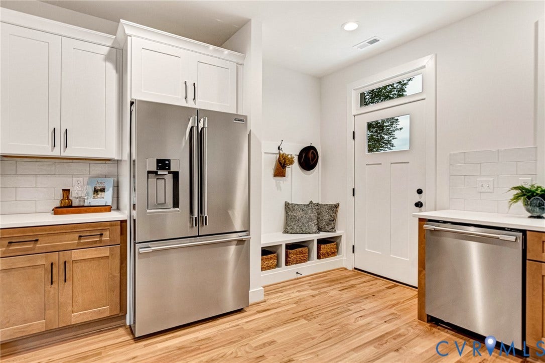 3021 E Franklin Street, St. John's Church, Richmond, VA 23223 Kitchen featuring wood-finish cabinetry, white upper cabinetry, stainless steel appliances, subway tile backsplash, and built-in bench seating