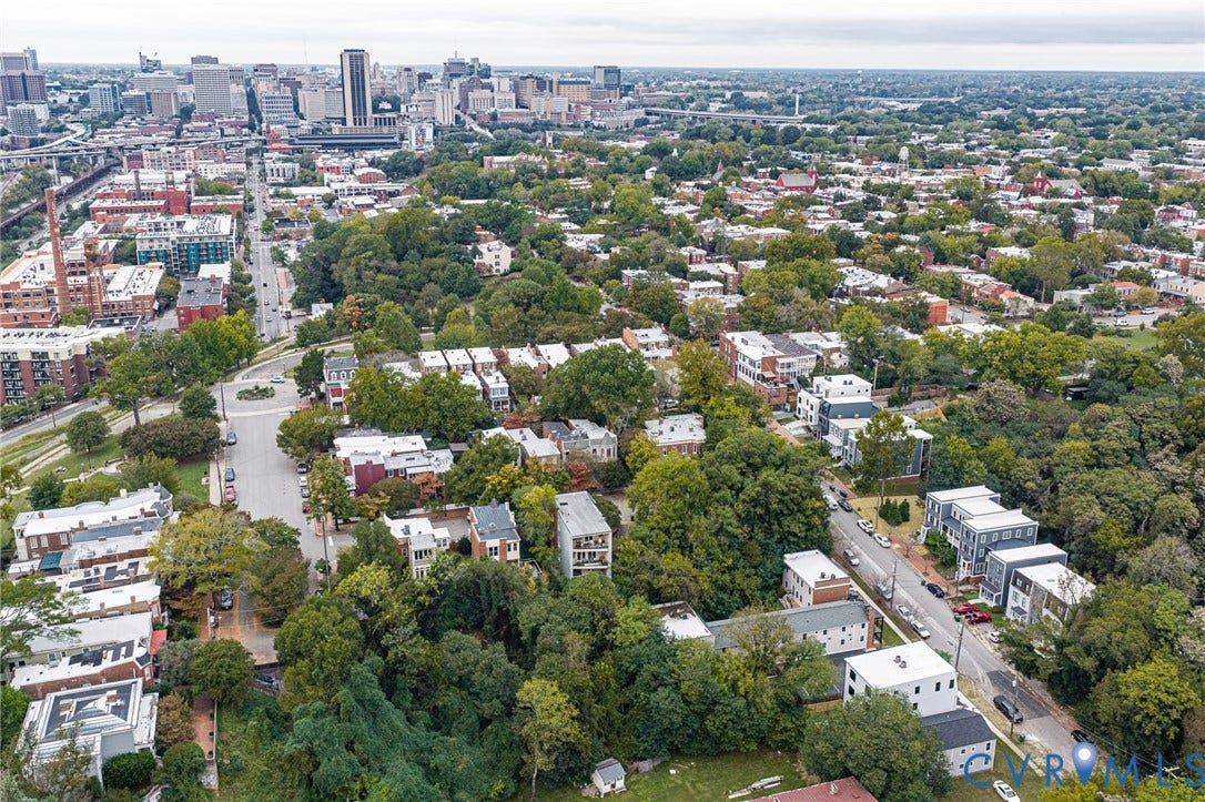 3021 E Franklin Street, St. John's Church, Richmond, VA 23223 Aerial perspective featuring a metropolitan skyline backdrop, dense mature tree canopy, and established residential street grid
