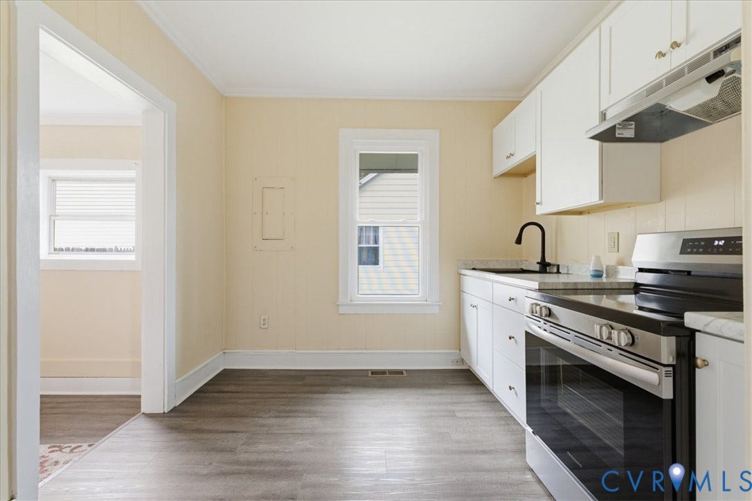 100 N 3rd Avenue, Hopewell, VA 23860 Kitchen featuring white cabinetry, wood-finish flooring, a stainless steel range, and a matte black faucet