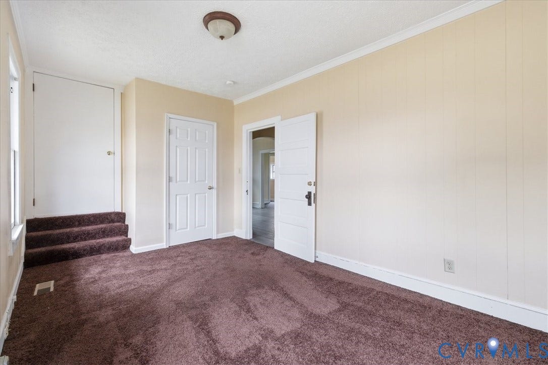 100 N 3rd Avenue, Hopewell, VA 23860 Interior space featuring white paneled doors, crown molding, wall-to-wall carpeting, and a built-in step configuration