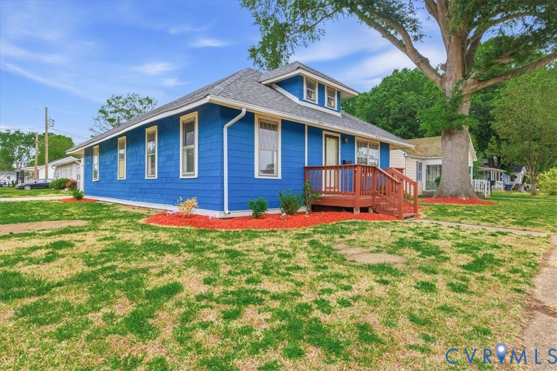100 N 3rd Avenue, Hopewell, VA 23860 Craftsman-style residence featuring blue horizontal siding, a gabled roofline, a raised wooden front porch, and a large mature shade tree