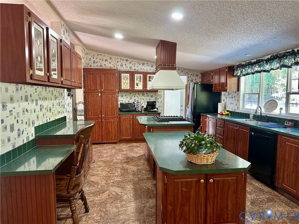 25400 SAYLERS CREEK ROAD, Deatonville, Jetersville, VA 23083 Kitchen featuring wood cabinetry, a center island with integrated cooktop, a dedicated desk area, a range hood with custom cabinetry housing, and solid-surface countertops