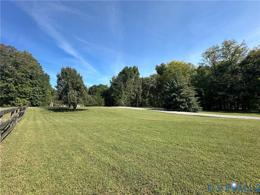 25400 SAYLERS CREEK ROAD, Deatonville, Jetersville, VA 23083 Expansive grounds featuring a manicured lawn, perimeter split-rail fencing, mature trees, and a stone-surface driveway