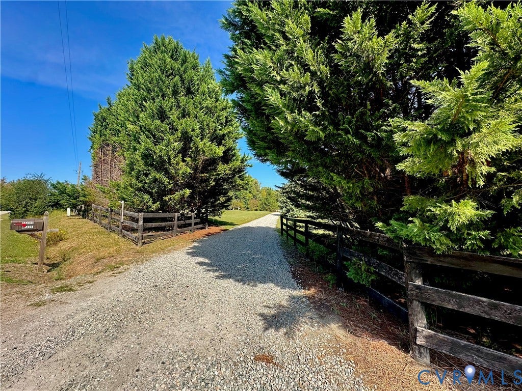 25400 SAYLERS CREEK ROAD, Deatonville, Jetersville, VA 23083 Gravel driveway bordered by dark wood post-and-rail fencing and mature evergreen trees