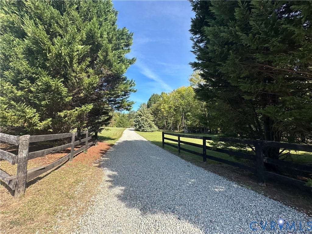 25400 SAYLERS CREEK ROAD, Deatonville, Jetersville, VA 23083 Gravel driveway bordered by dark-finished post-and-rail fencing and mature evergreen trees
