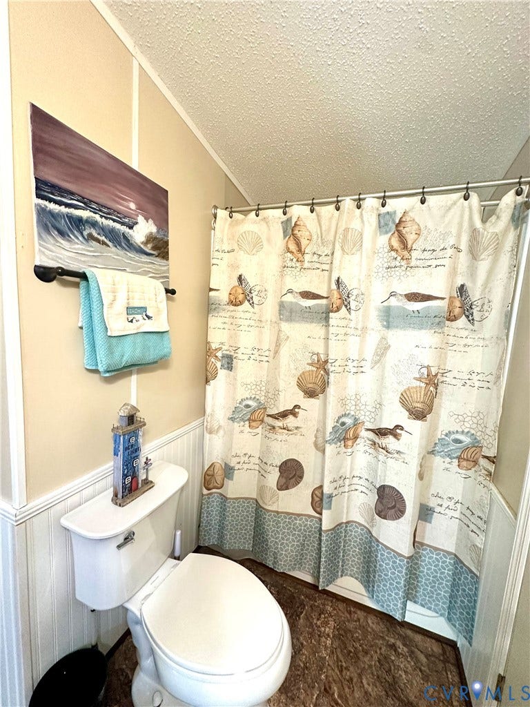 25400 SAYLERS CREEK ROAD, Deatonville, Jetersville, VA 23083 Bathroom featuring white wainscoting, a standard toilet, and a bathtub with an integrated shower rod