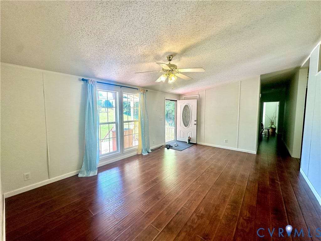25400 SAYLERS CREEK ROAD, Deatonville, Jetersville, VA 23083 Living area featuring wood-finish flooring, ceiling fan with integrated lighting, dual window configuration, and exterior door with decorative glass insert
