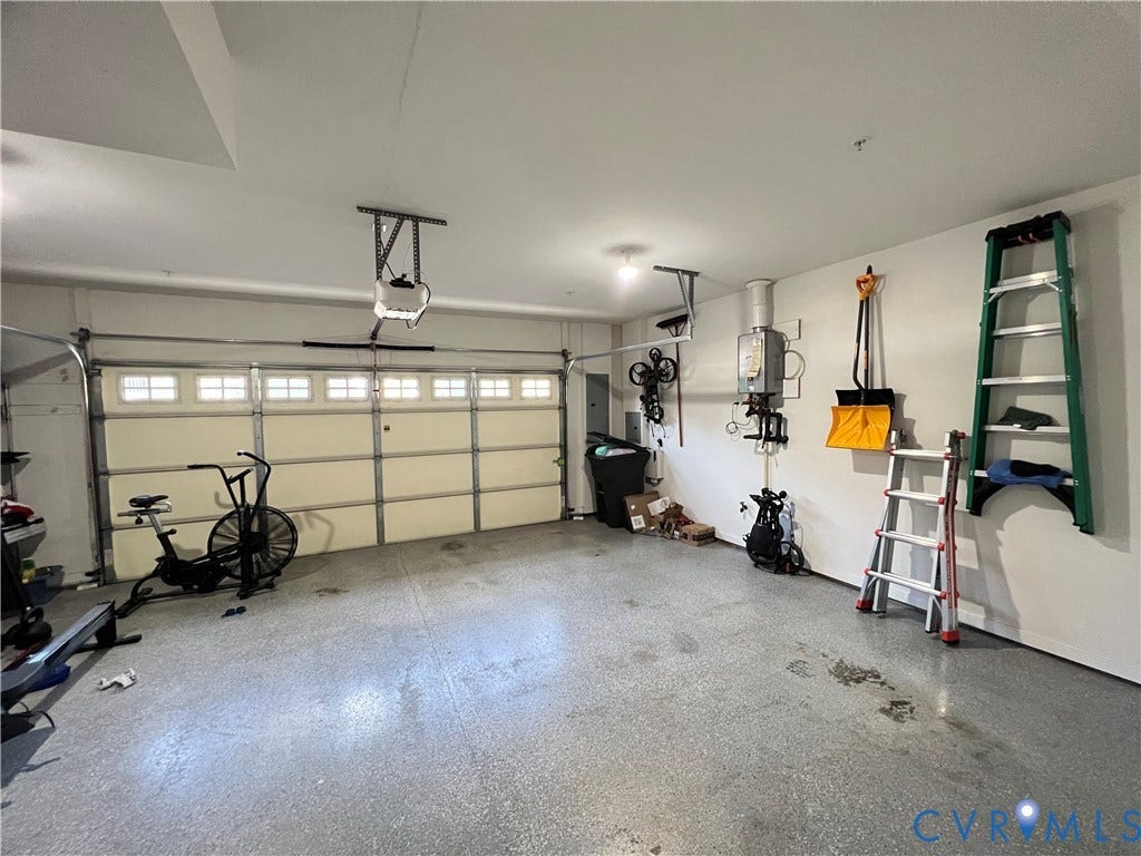 2310 Liesfeld Parkway, West Broad Village, Henrico, VA 23060 Two-car garage featuring a sectional door with windows, an epoxy-coated floor, and a wall-mounted tankless water heater
