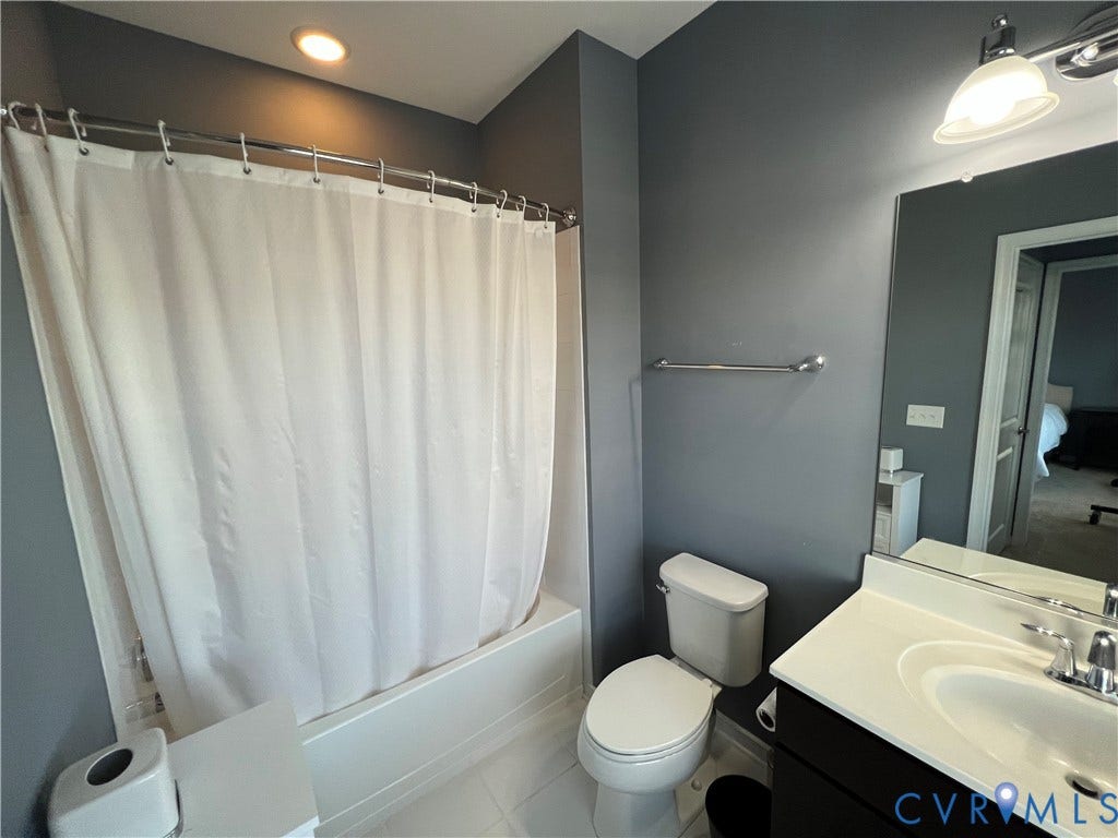 2310 Liesfeld Parkway, West Broad Village, Henrico, VA 23060 Bathroom featuring a tub-shower combination with surround, a vanity with a white countertop and integrated sink, a large wall-mounted mirror, and polished chrome hardware