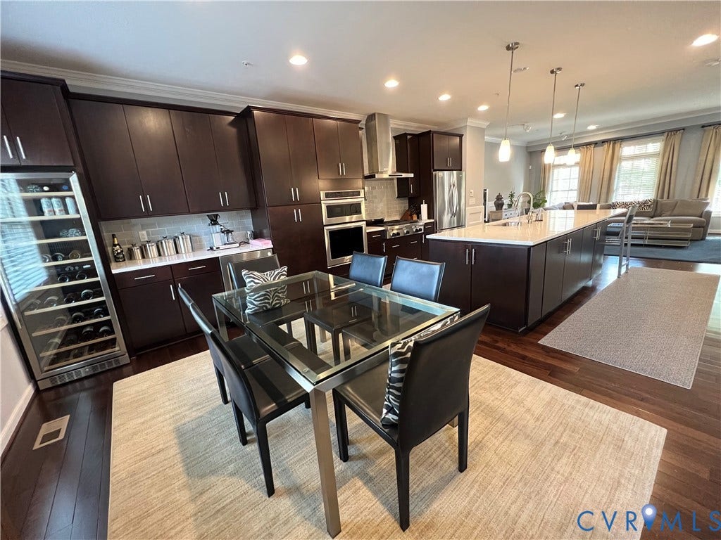 2310 Liesfeld Parkway, West Broad Village, Henrico, VA 23060 Kitchen featuring dark wood cabinetry, a large center island with a white countertop, built-in stainless steel appliances, a recessed wine cooler, and dark wood-finish flooring
