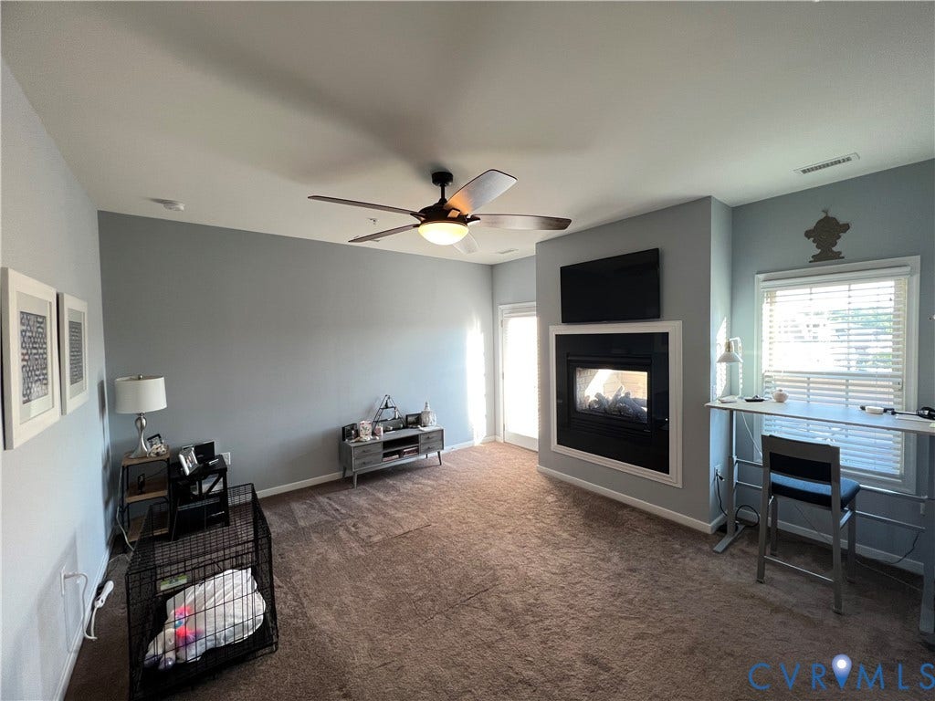 2310 Liesfeld Parkway, West Broad Village, Henrico, VA 23060 Built-in fireplace with a black surround, ceiling fan with integrated lighting, window with horizontal blinds, and carpeted flooring