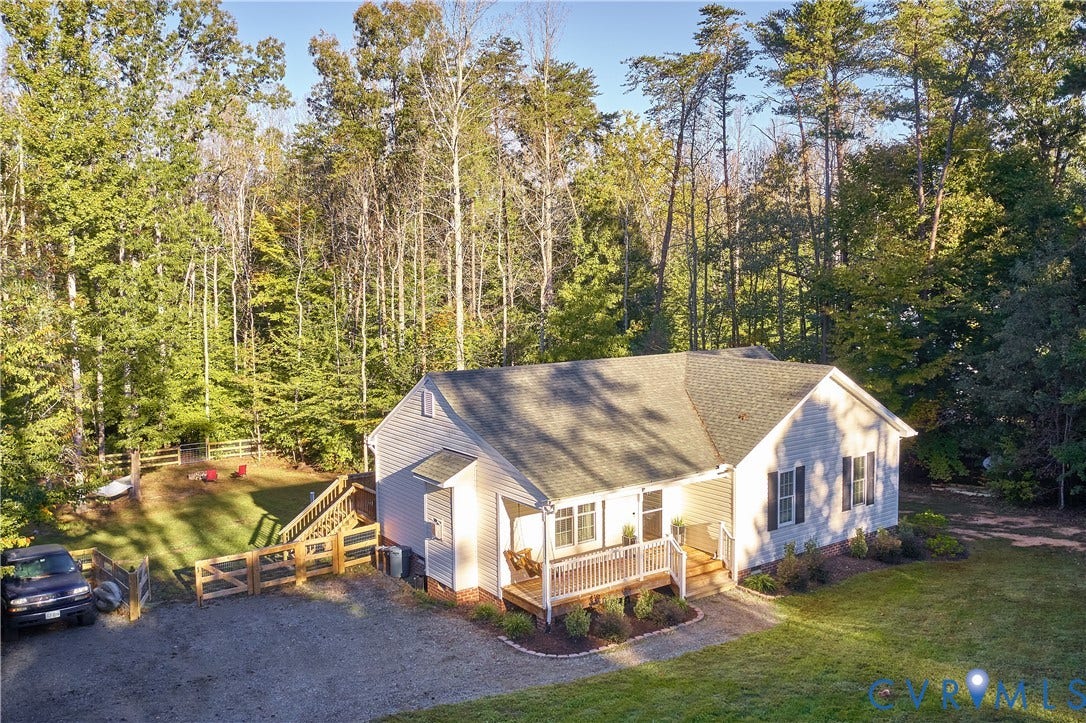 444 Tillar Lane, Mineral, VA 23117 Single-story residence featuring light-colored horizontal siding, an asphalt shingle roof, a covered front porch with railing, a gravel driveway, and a fenced side yard area