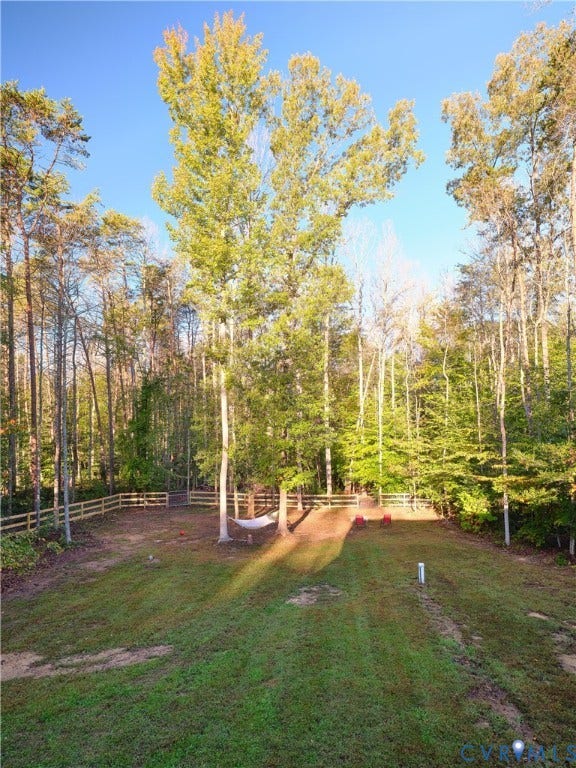 444 Tillar Lane, Mineral, VA 23117 Expansive backyard featuring a level lawn, perimeter wood-post fencing, and mature trees