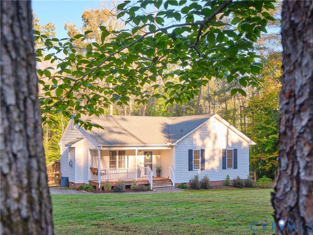 444 Tillar Lane, Mineral, VA 23117 Single-story residence featuring light-colored siding, a covered front porch with white railing, brick foundation detailing, and dark shutters