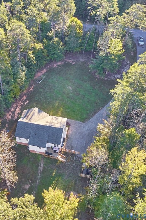 444 Tillar Lane, Mineral, VA 23117 Aerial perspective of a detached residence featuring a gravel driveway, wood-framed rear deck, and expansive grounds surrounded by mature trees