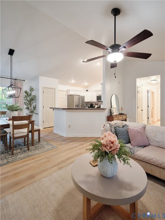 444 Tillar Lane, Mineral, VA 23117 Open-concept interior featuring vaulted ceilings, wood-finish flooring, a matte black multi-light pendant fixture, and a ceiling fan with dark wood-finish blades