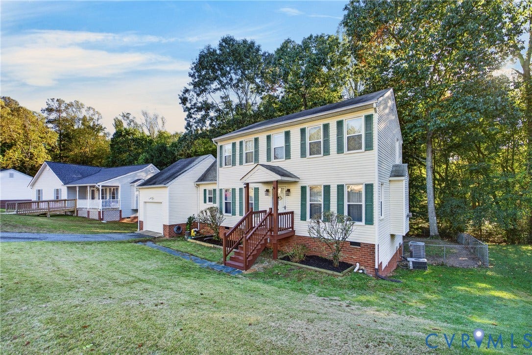 7225 Hartsdale Court, Chesterfield, VA 23832 Two-story exterior featuring light-toned horizontal siding, dark shutter accents, brick foundation detail, a front-facing attached garage, and elevated wooden porch steps