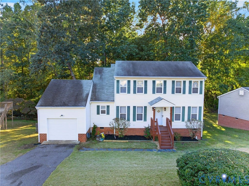 7225 Hartsdale Court, Chesterfield, VA 23832 Two-story colonial-style residence featuring light-toned horizontal siding, brick foundation accents, dark-framed window shutters, an attached garage, and a front entry porch with wooden stairs