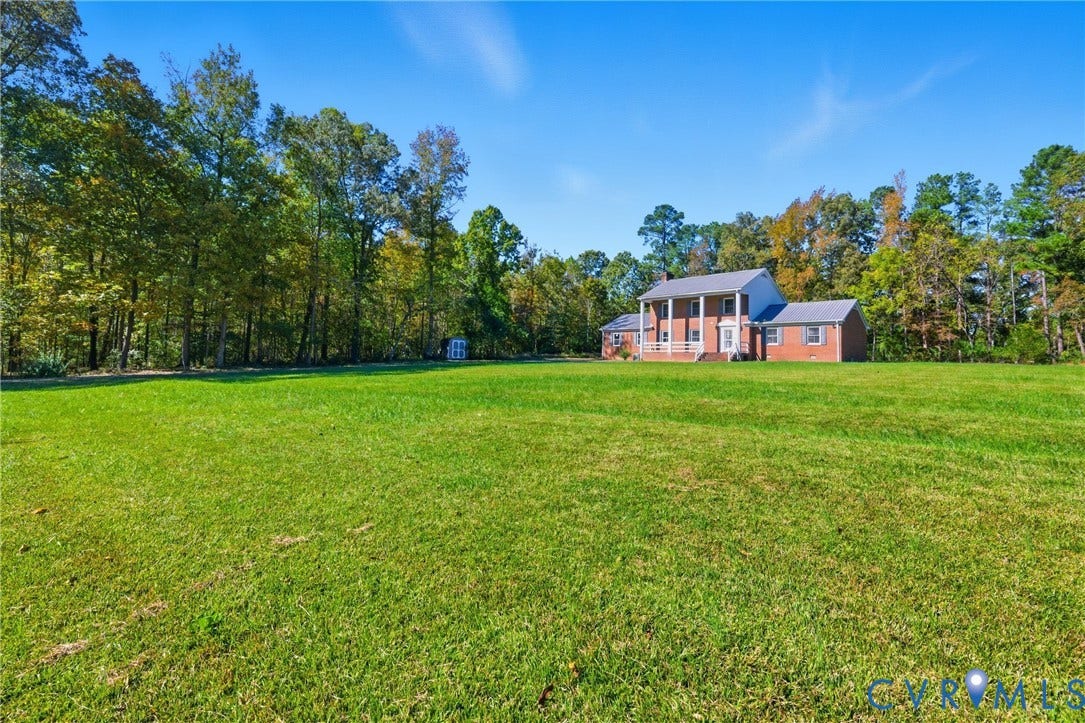 13225 Old Happy Hill Road, Chester, VA 23831 Expansive grass lawn featuring mature perimeter trees, two-story brick exterior, and front porch with supporting columns