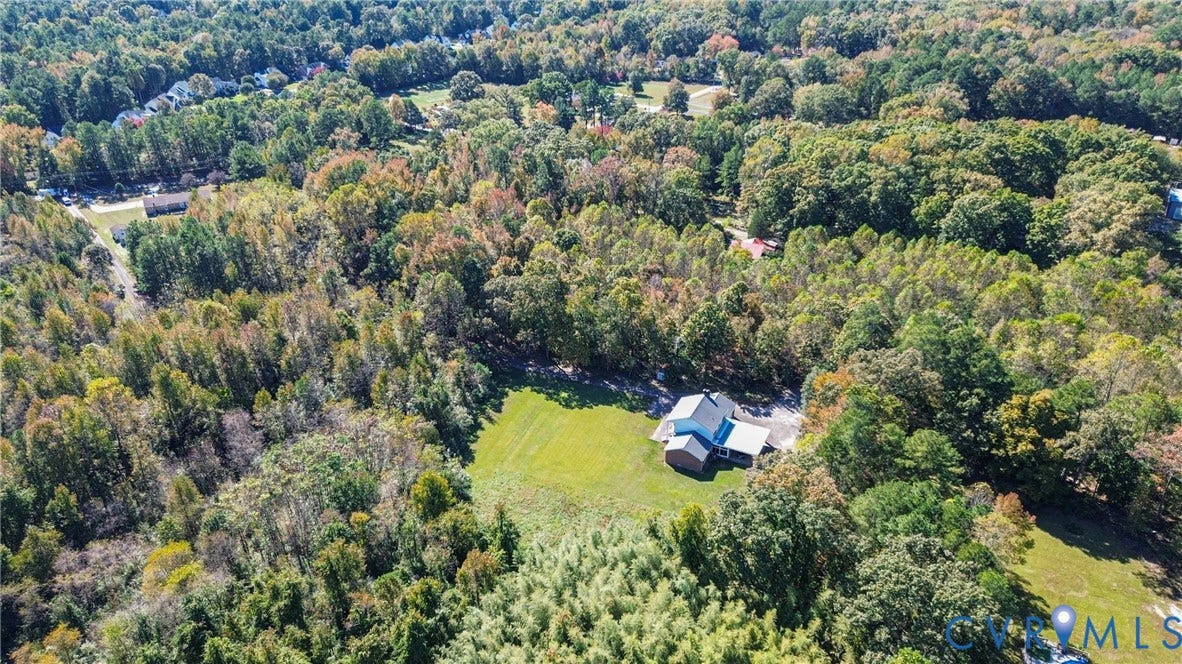 13225 Old Happy Hill Road, Chester, VA 23831 Aerial perspective of a detached residence featuring a multi-gabled roofline, an attached garage, a paved driveway, and expansive acreage comprised of open lawn and mature forest