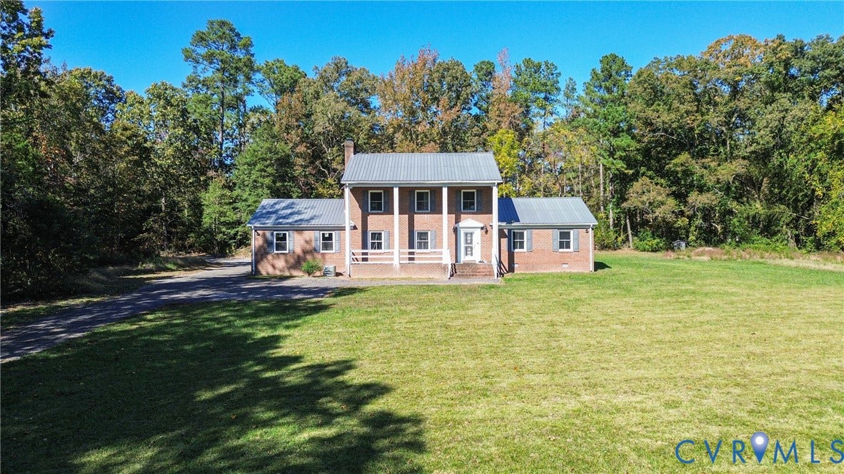 13225 Old Happy Hill Road, Chester, VA 23831 Two-story brick exterior featuring a metal roof, front porch with columns, shutter-framed windows, and an expansive lawn