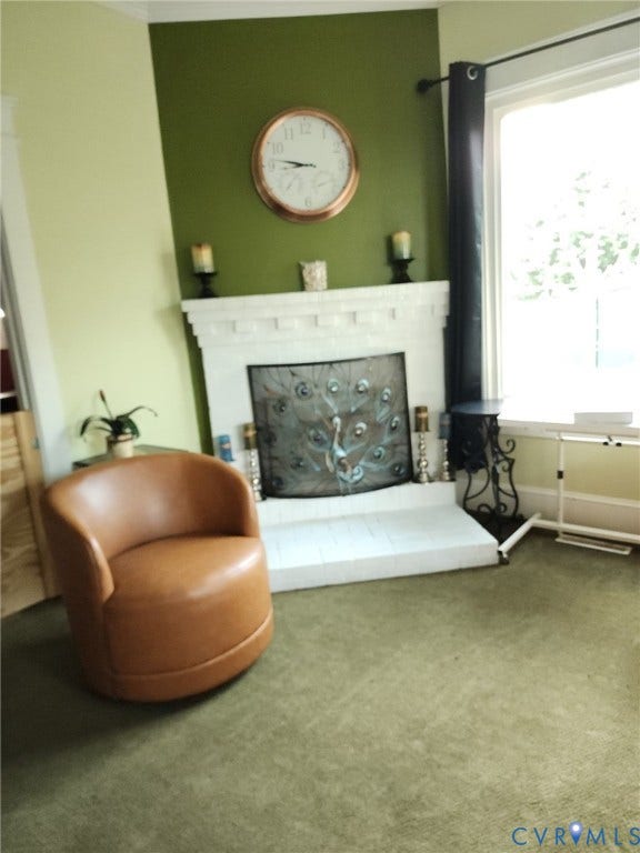 115 Katherine Street, Kings Borough, Suffolk, VA 23434 Painted brick fireplace featuring a classic mantel and hearth, large window with expansive glazing, and neutral wall tones